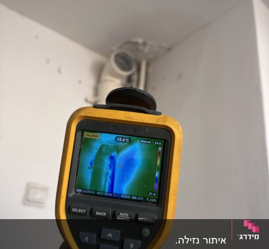מד חום תרמי ביד בודק נזילה בקיר